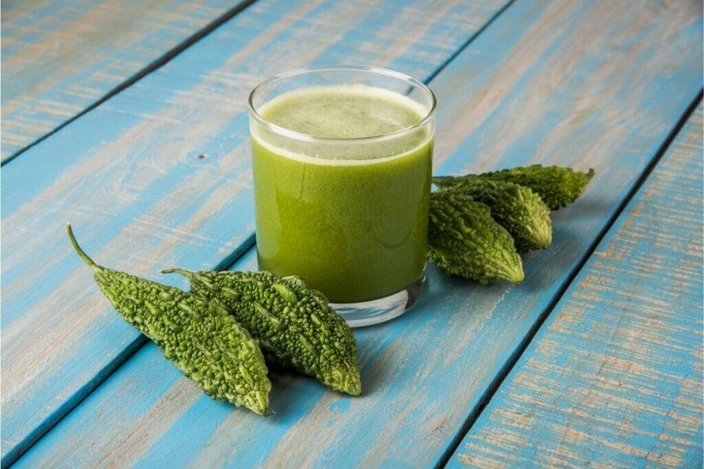 Image of bitter gourd/bitter melon vegetable with a glass of bitter gourd juice