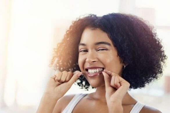Importance of oral health - Image of a girl flossing her teeth