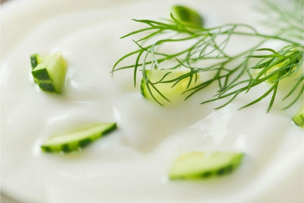 Yogurt with cucumber slice and culinary herb