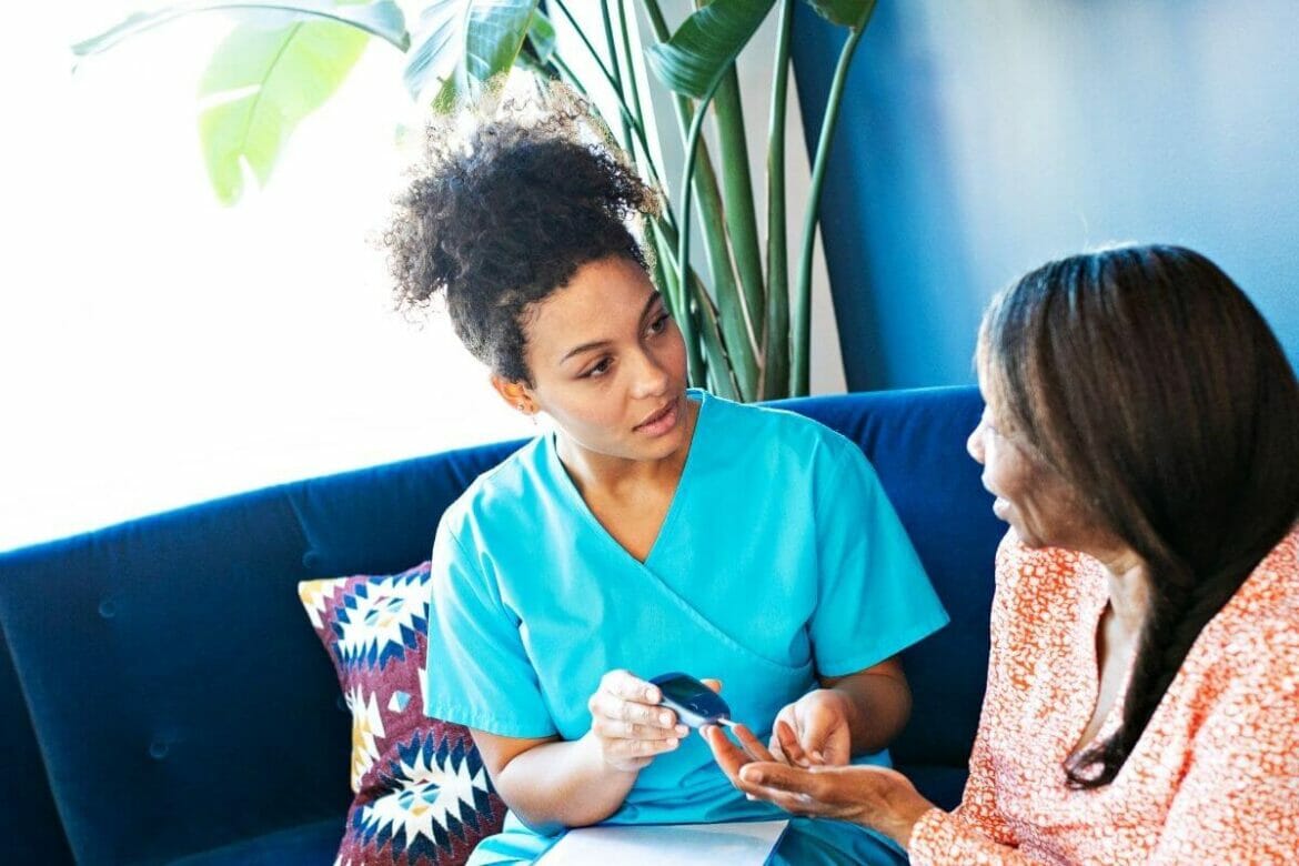 Daughter checking blood sugar of her mom