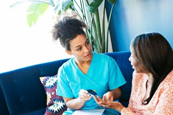 Daughter checking blood sugar of her mom