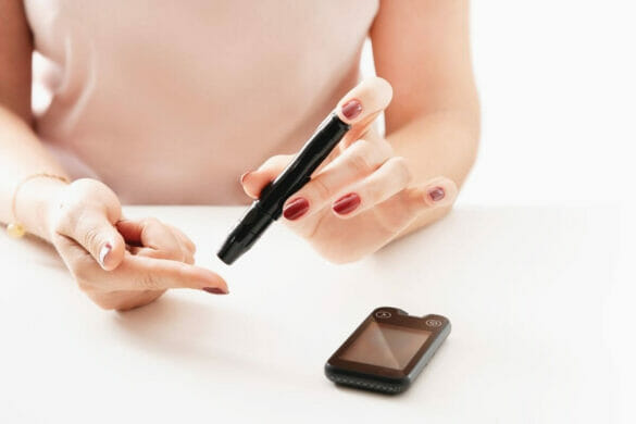 Image of a Woman checking blood sugar with text manage blood sugar naturally