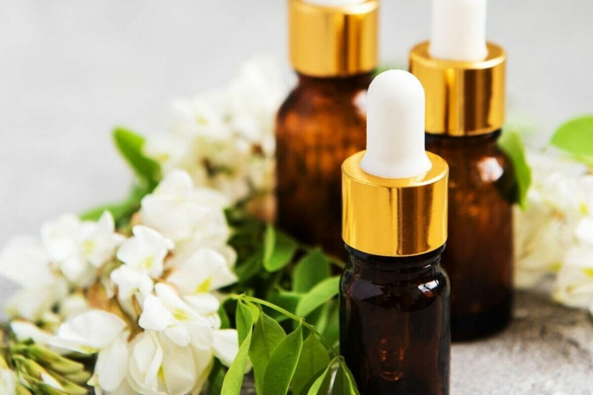 Aromatherapy Essential oils in bottles with white flowers in background