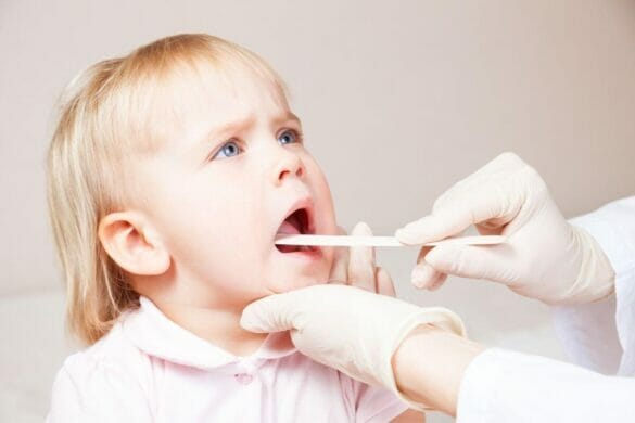 Small girl being examined for sore throat