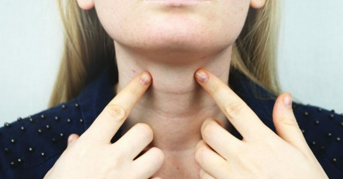 Woman touching her thyroid gland
