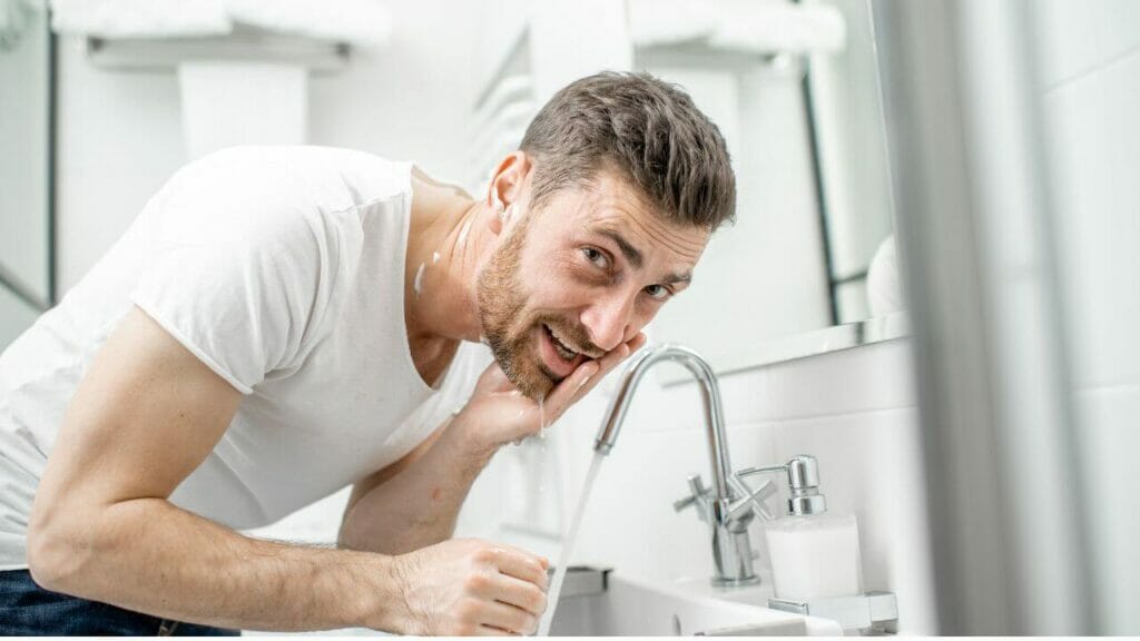 Image of a man washing his face with clear water
