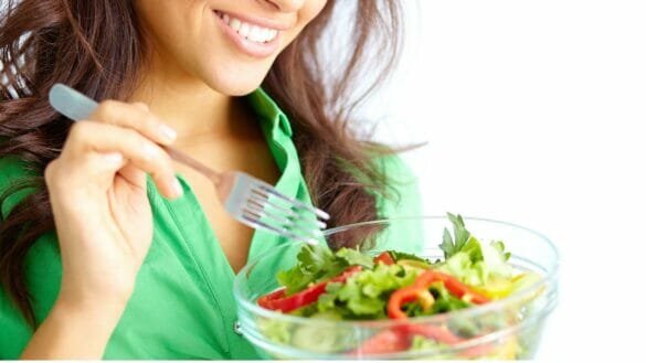 DASH diet for hypertension concept - woman enjoying a variety of vegetables as a salad