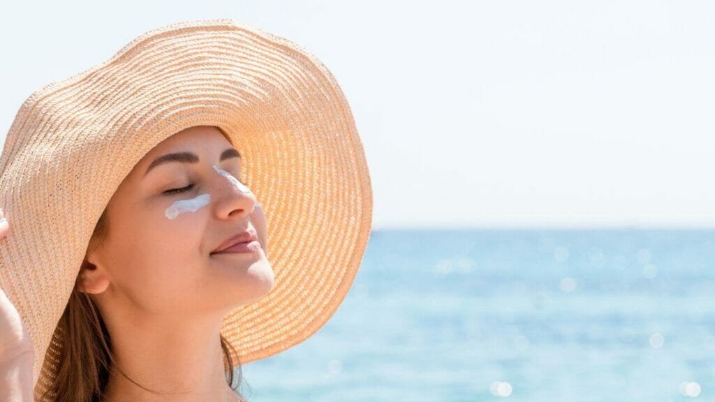 Image of a woman under the sun wearing a brimmed hat and sunscreen