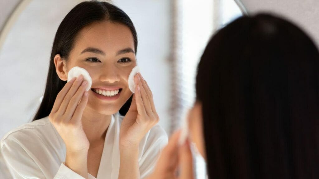 Image of a young woman removing her makeup - a good skincare routine