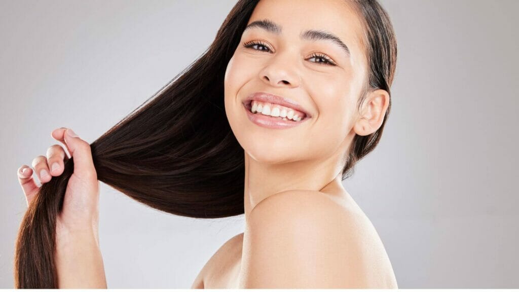 Smiling young woman with oiled hair - ayurveda haircare routine for dosha imbalance