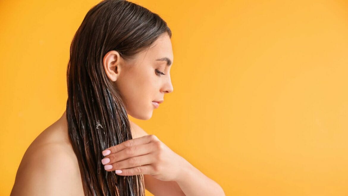 Image of a woman oiling hair for benefits