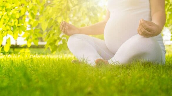Image of a pregnant woman practising yoga and meditation to relieve stress and anxiety during pregnancy