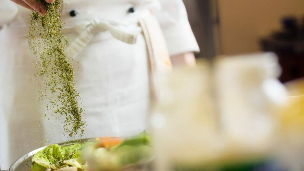 Image of a chef using spices on food