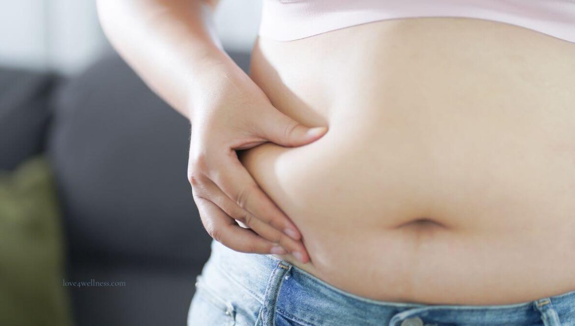 Woman approaching menopause examining her belly bulge