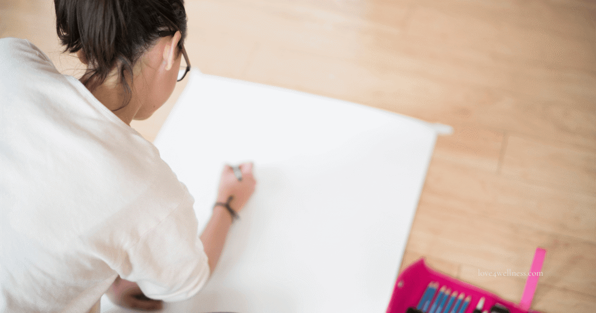 A young girl drawing on a paper - engaging in activities like drawing, singing, etc. help manage anxiety in students