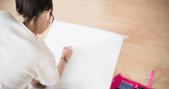A young girl drawing on a paper - engaging in activities like drawing, singing, etc. help manage anxiety in students