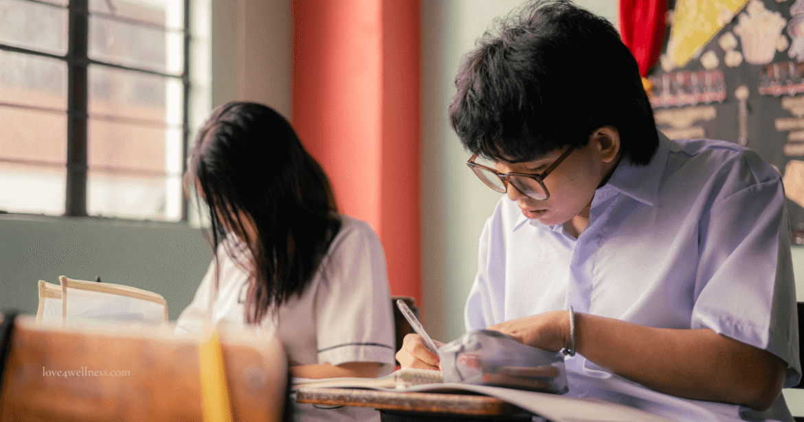Students writing in notebooks in a classroom, reflecting obedience vs intelligence in students